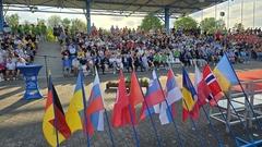 Die Fahnenreihe zeigt die bunte internationale Vielzahl.