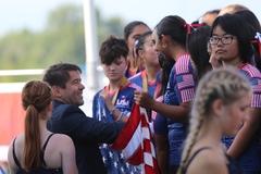 Steffen Scheller bei der Medaillenvergabe an USA-Sportlerinnen.