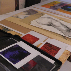 Foto von Bildern und Skizzen liegend auf einem Tisch im Atelier von der Künstlerin Stefanie Rinkenbach.